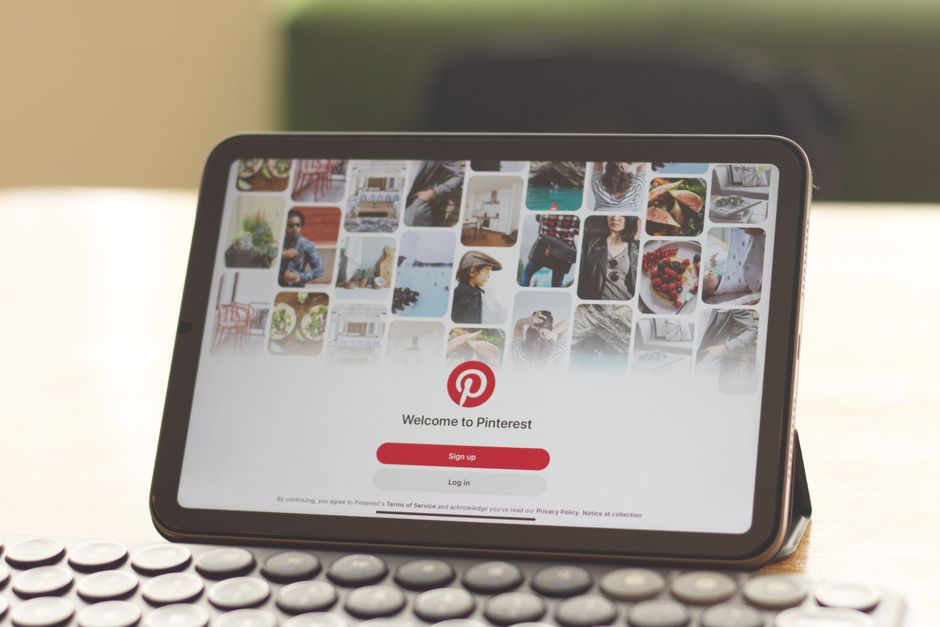 Ahşap bir masada Pinterest giriş ekranını gösteren bir tablet.