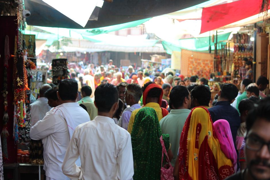 A bustling outdoor market in Pushkar, India with vibrant clothing and diverse crowd.